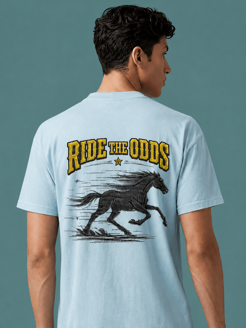 Man wearing the Ruxel Ride the Odds western tee in light blue, back view - galloping black horse, a star and gold RIDE THE ODDS lettering