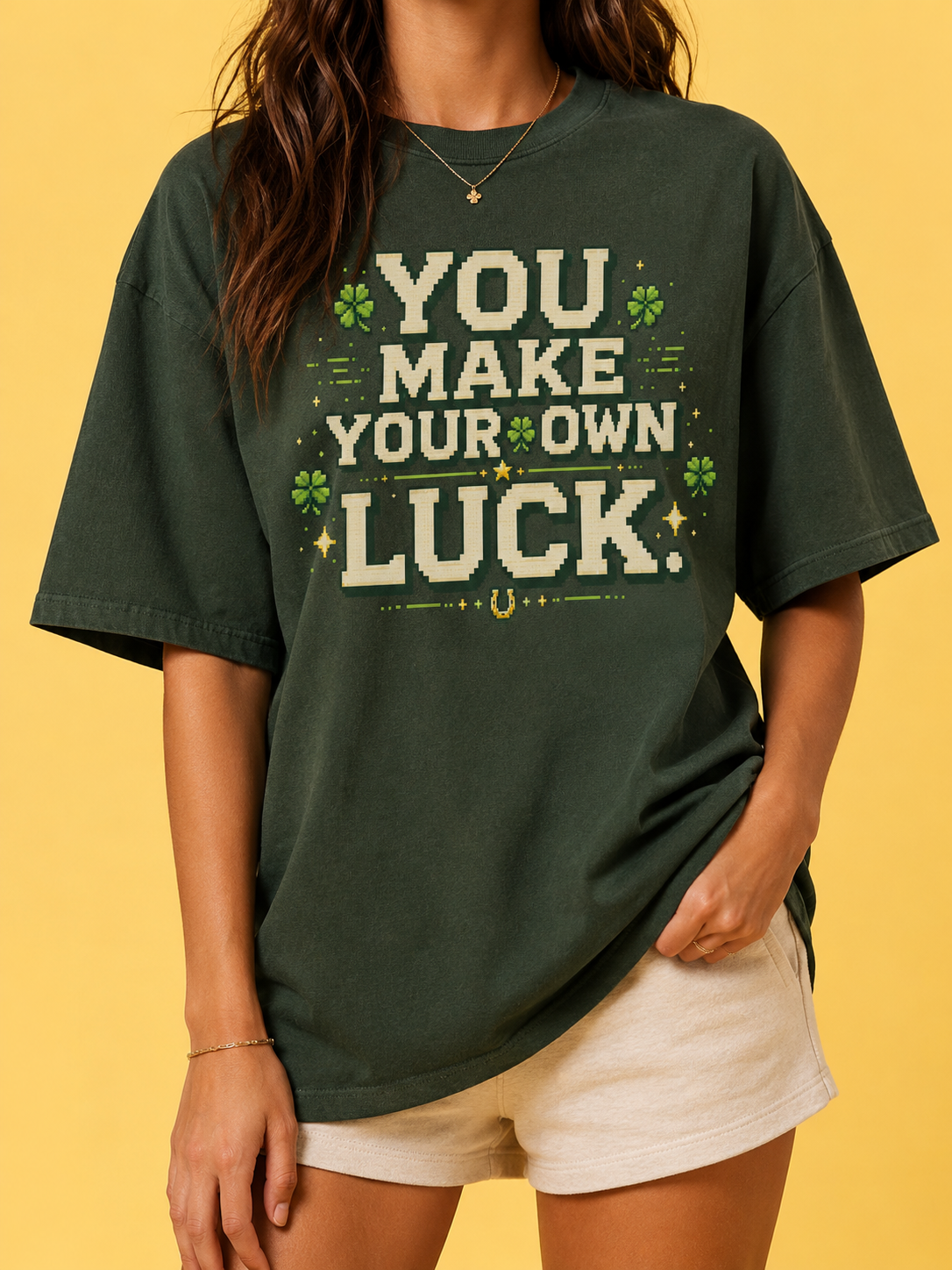 Woman wearing the Ruxel You Make Your Own Luck tee in Clover Green, front view - cream pixel text with four-leaf clovers, gold stars and a horseshoe