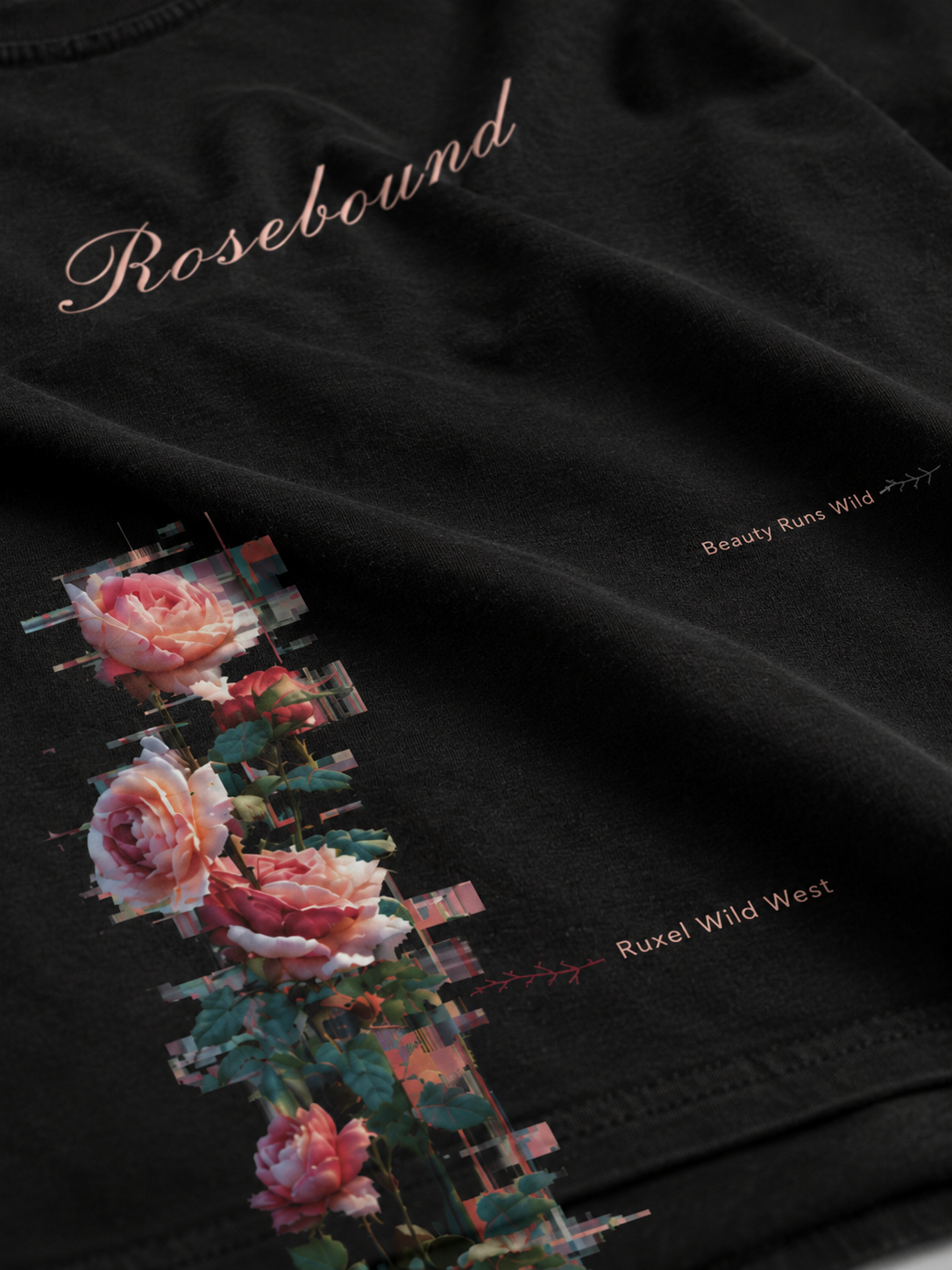 Close-up of the Rosebound front print on Ruxel Void Black garment-dyed cotton - Rosebound script, a glitching rose vine and Beauty Runs Wild / Ruxel Wild West text