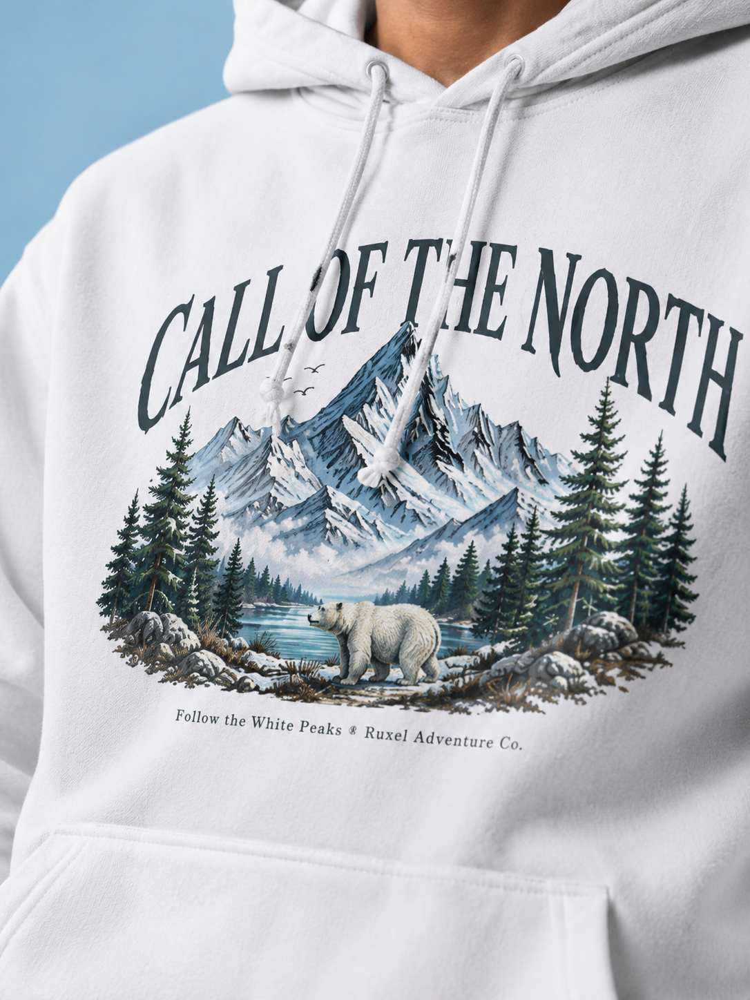 Close-up of the Call of the North front graphic on a Ruxel Arctic White heavyweight hoodie - mountains, pines and a polar bear