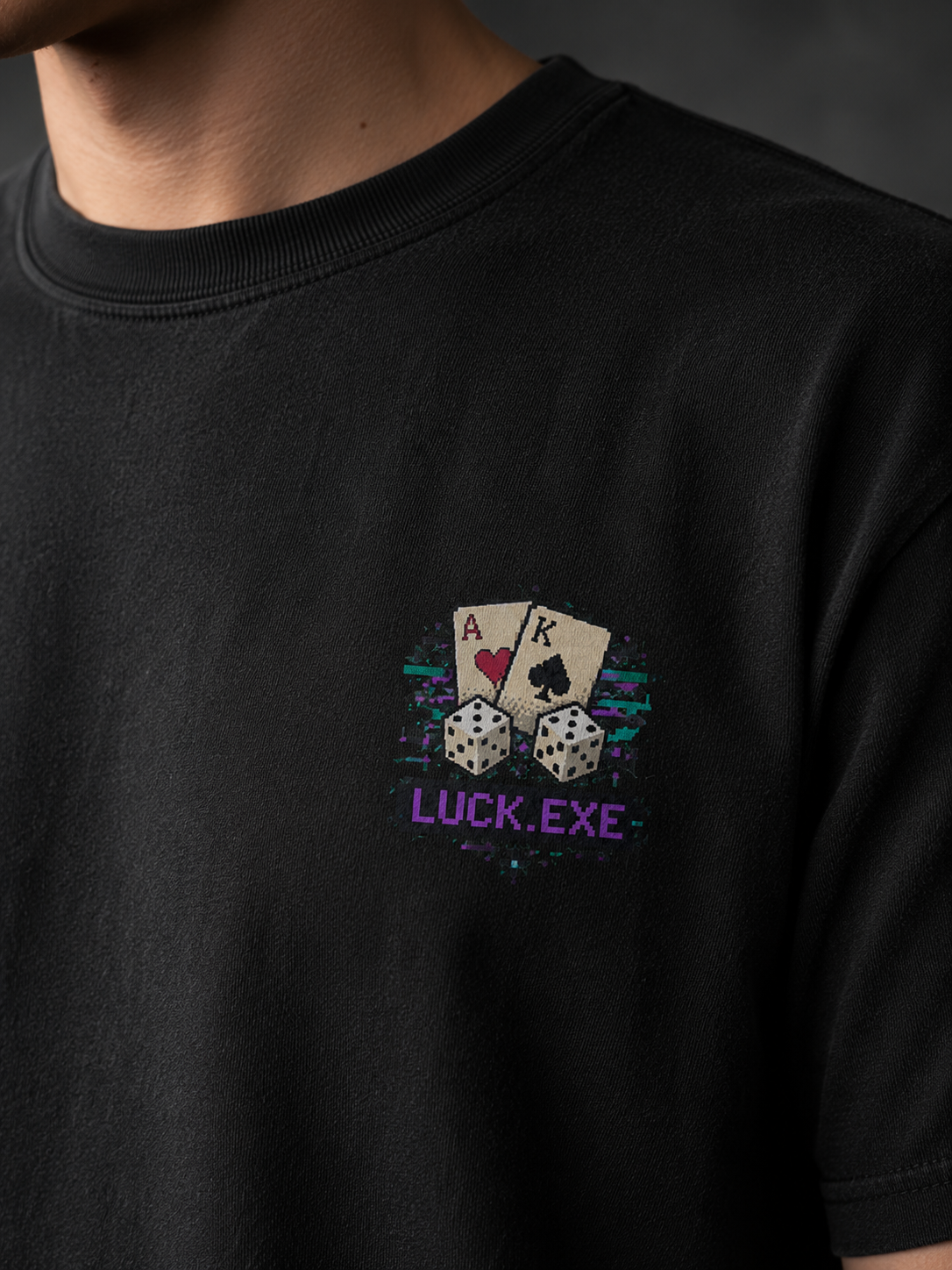 Close-up of the Ruxel Luck.exe chest print on Vintage Black garment-dyed cotton - pixel-art ace and king cards, dice and LUCK.EXE with glitch streaks
