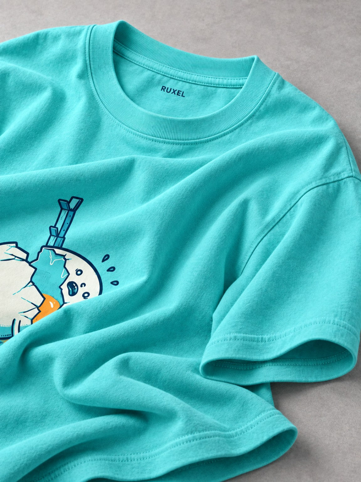 Close-up of the Ruxel neck label and garment-dyed fabric on the Electric Lagoon heavyweight tee
