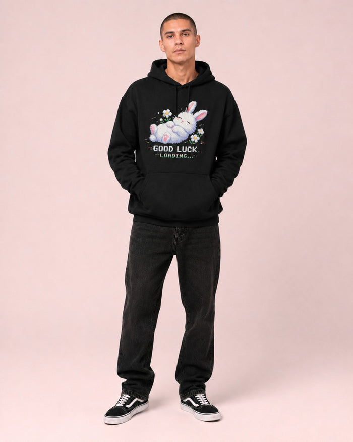 Male model wearing the Ruxel Good Luck Loading Void Black heavyweight hoodie, full front studio view with sleeping pixel bunny and daisies graphic