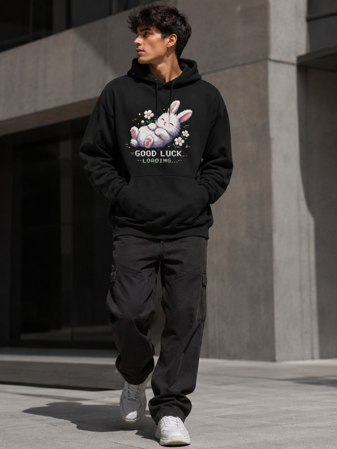 Male model walking in the Ruxel Good Luck Loading Void Black pixel bunny hoodie in a modern urban setting