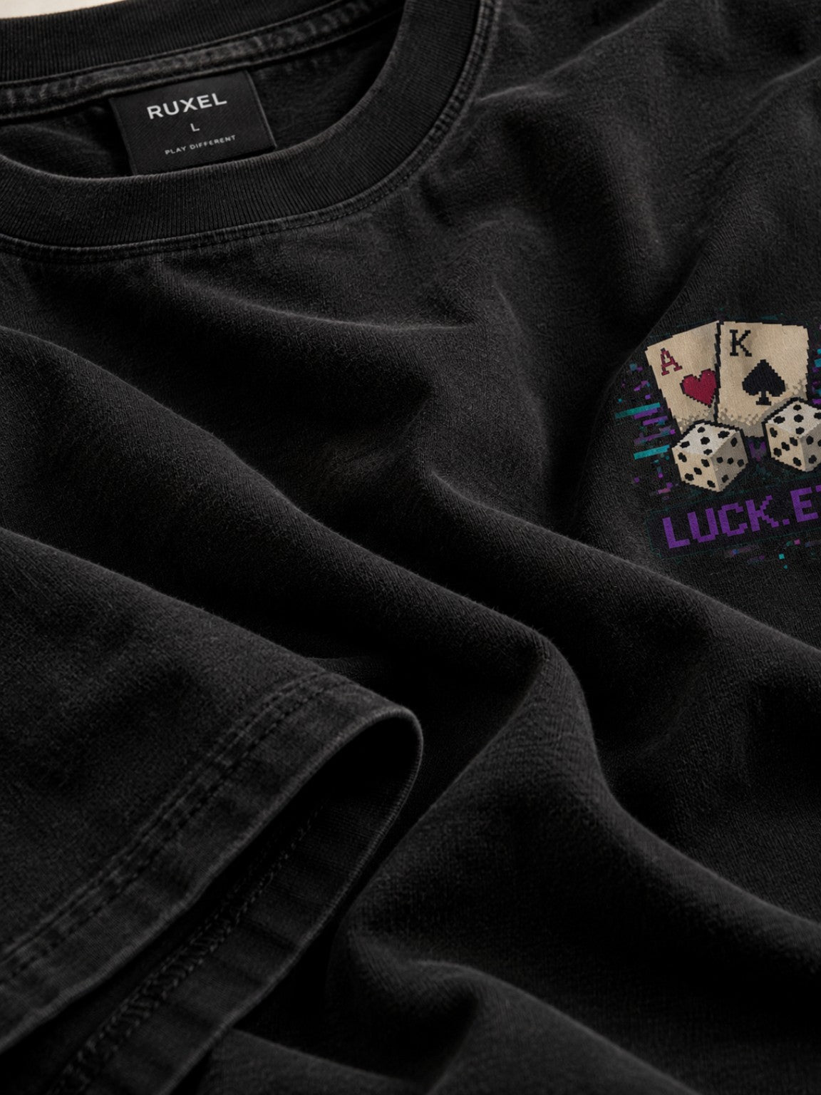 Ruxel Luck.exe Play the Hand Pixel Art Tee laid in soft folds, showing heavyweight Vintage Black cotton texture, collar construction and a partial chest graphic