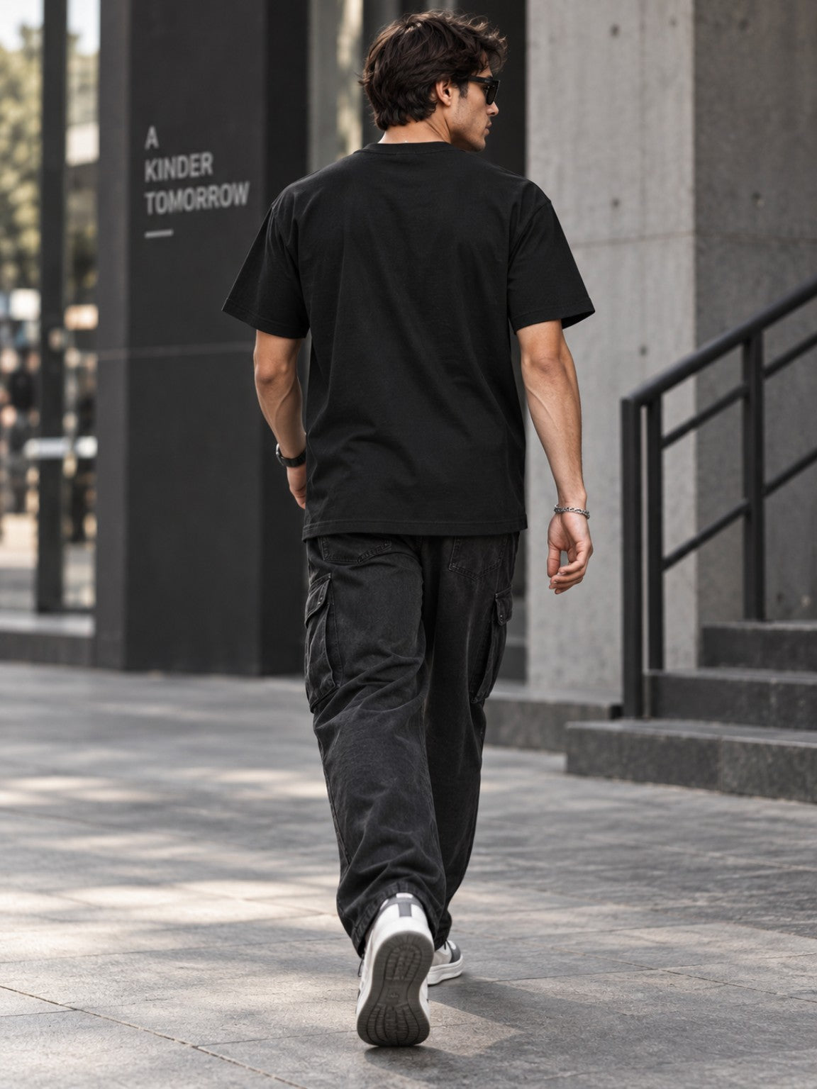 Male model wearing the Tethered Souls Eclipse Black heavyweight tee, plain back street view